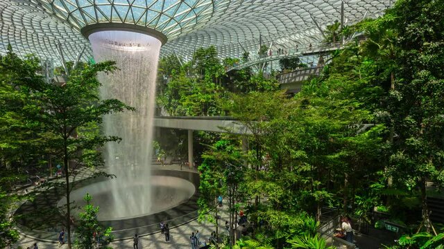 day light singapore city famous international airport modern world tallest indoor fountain crowded hall timelapse panorama 4k 