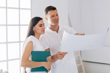 young couple discussing the plan for their new apartment.