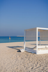 Fototapeta premium Relaxing empty beach with sun bed, sea landscape. Summer vacation travel holiday concept.