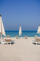 Relaxing empty beach with sun bed, sea landscape. Summer vacation travel holiday concept.
