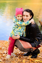 mother and daughter in the autumn Park on the river Bank