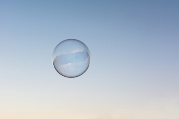 A soap bubble flying in the blue and clean sky