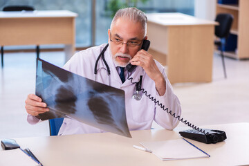 Old male doctor radiologist working in the clinic