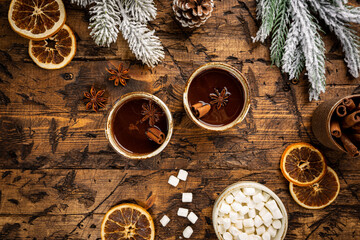 Christmas background with fir tree, cup of hot cocoa or chocolate and marshmallow on wooden background. Top view with copy space