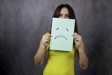 young woman covered herself with a mask with a sad emotion