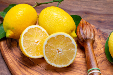 Fresh ripe yellow Italian lemons and wooden juice squeezer, new harvest