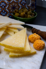 Spanish snacks tapas, variety of sliced goat, sheep, manchego cheeses, green olives