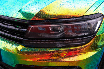 Chameleon holographic colour car in the rain. Car wrapping with iridescent paint. Raindrops on the...