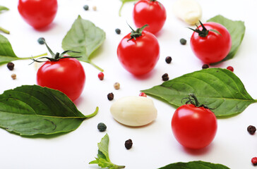 Tomato, basil, spices, pepper, garlic. Vegan diet food, creative cherry tomato composition isolated on white.