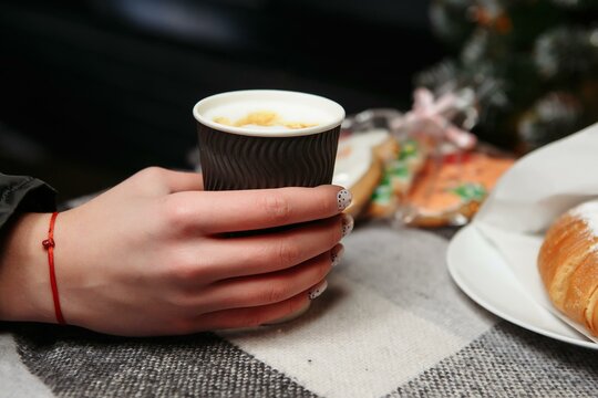 hands hold a hot cup of coffee. Coffee to go in winter