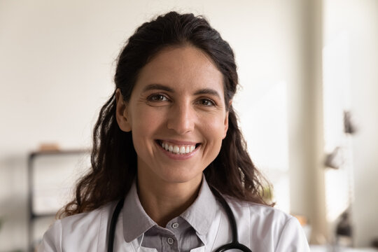 Close up portrait of smiling young Caucasian female doctor or nurse pose in private hospital or clinic. Happy confident woman GP or physician feel optimistic motivated work in medical institution.