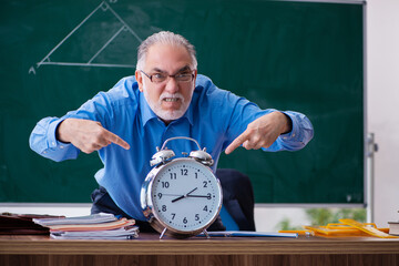 Old male math teacher in time management concept