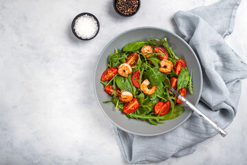 Salad of shrimp prawn and fresh vegetable, leaves of arugula, lettuce.