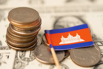 Stack of coins with Cambodia flag on US dollar banknotes background.