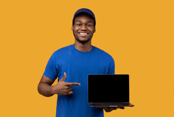 Black delivery man holding laptop with blank screen for mockup