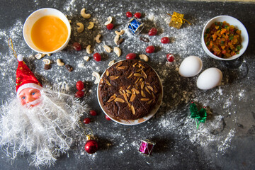 Pieces of almonds on cake along with cake baking ingredients on a background as part of Christmas and new year celebrations