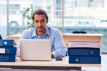 Young male employee and too much work in the office