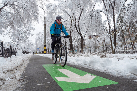 A man rides a bike in the winter along the bike path. Eco-friendly mode of urban transport
