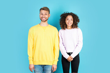 Two mixed race people standing on blue background