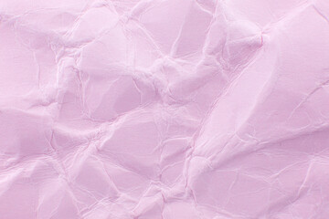 Crumpled pink paper background. Real macro battered texture. Close up photo.