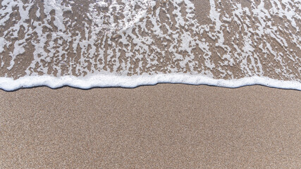 Sparkling waves hitting the shore on the beach on sunny day at Summer, sand beige background image, Holiday, Travel Concept in Antalya Turkey.