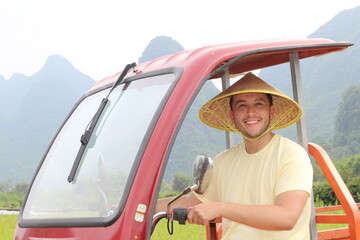 Asian man driving taxi in rural area 