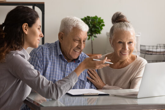 Female banking specialist consult happy mature couple about loan or mortgage at meeting in office. Woman consultant advise recommend elderly spouses good medical life health insurance on computer.