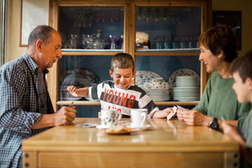 Family playing cards around the table.