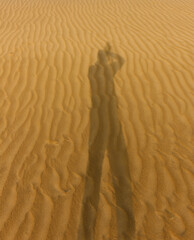 Shadow of a photographer on the desert sand