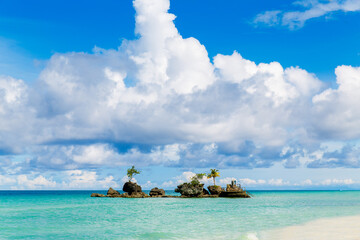 Beautiful landscape of tropical beach and Willis rock on Boracay island, Philippines. Coconut palm trees, sea, sailboat and white sand. Nature view. Summer vacation concept.