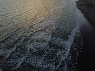 Sunset on Atlantic ocean Argentine coasts, brown sand and blue waves, picture with a drone. Monte Hermoso, Argentina