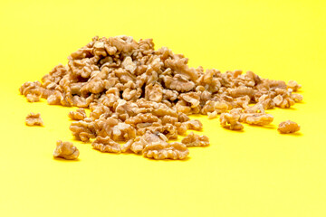 Walnuts, a bunch of peeled walnuts on a yellow background.
