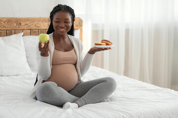 Pregnancy Diet. Smiling Pregnant Woman Choosing Green Apple Instead Of Unhealthy Donuts