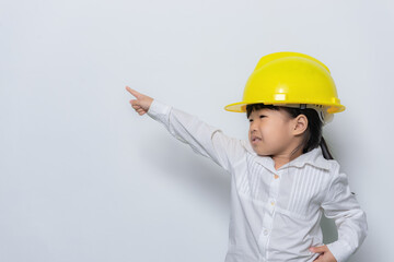 Portrait of cute asian little girl in engineer uniform and helmet on white background