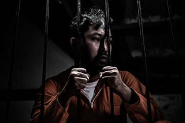 Asian man desperate at the iron prison,prisoner concept,thailand people,Hope to be free,Serious...