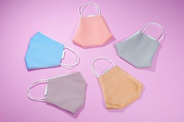 Multicolored face masks on pink background