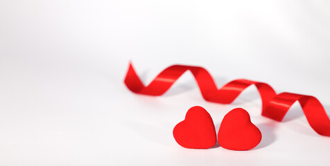 Two red hearts and red ribbon on white background. Concept for Valentin's day. Banner. Place for...