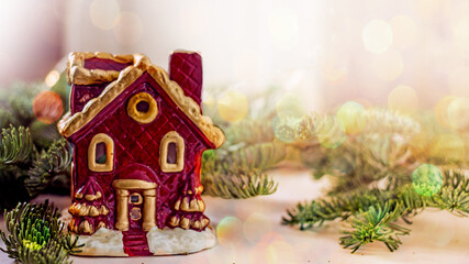 Home Sweet Home. Decorative house red candlestick on the background of a spruce branch, bokeh, copy space