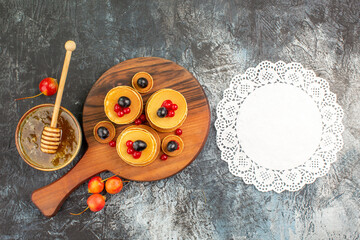 Breakfast time with fruit pancakes on cutting board on gray background