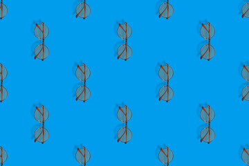 Background on the theme of glasses for vision. Glasses seamless pattern on a blue background.