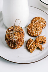 Cereal cookies with a carafe of milk on a white plate