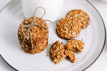 Cereal cookies with a carafe of milk on a white plate