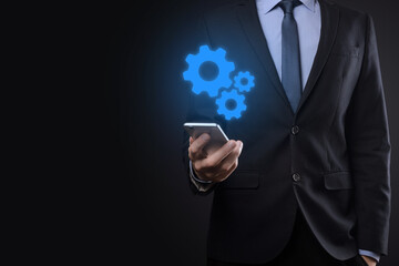 Business man in suit holding metal gears and cogwheels mechanism representing interaction teamwork concept,hand hold group of virtual cog gears wheel