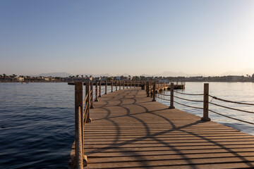 Hurghada, Egypt - September 28 2020: View of the wooden boardwalk over the Red Sea during sunset in...