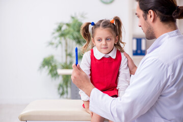 Small girl visiting young male doctor oculist