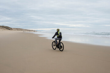 Obraz na płótnie Canvas man doing electric fat bike on the beach