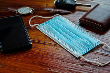 Surgical mask on table with man's objects