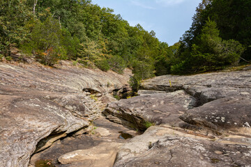 Barren rock formations and small creek run between the trees in the Bell Smith Springs area of the Shawnee National Forest.