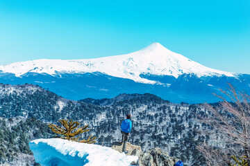 a person looking the villarrica volcano, winter time snow