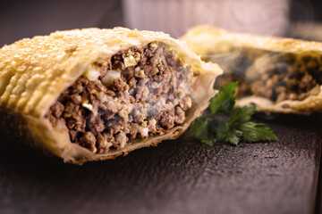 fried meat pastry cut in half, stuffed with minced meat and potatoes and hot sauce. Typical food in...